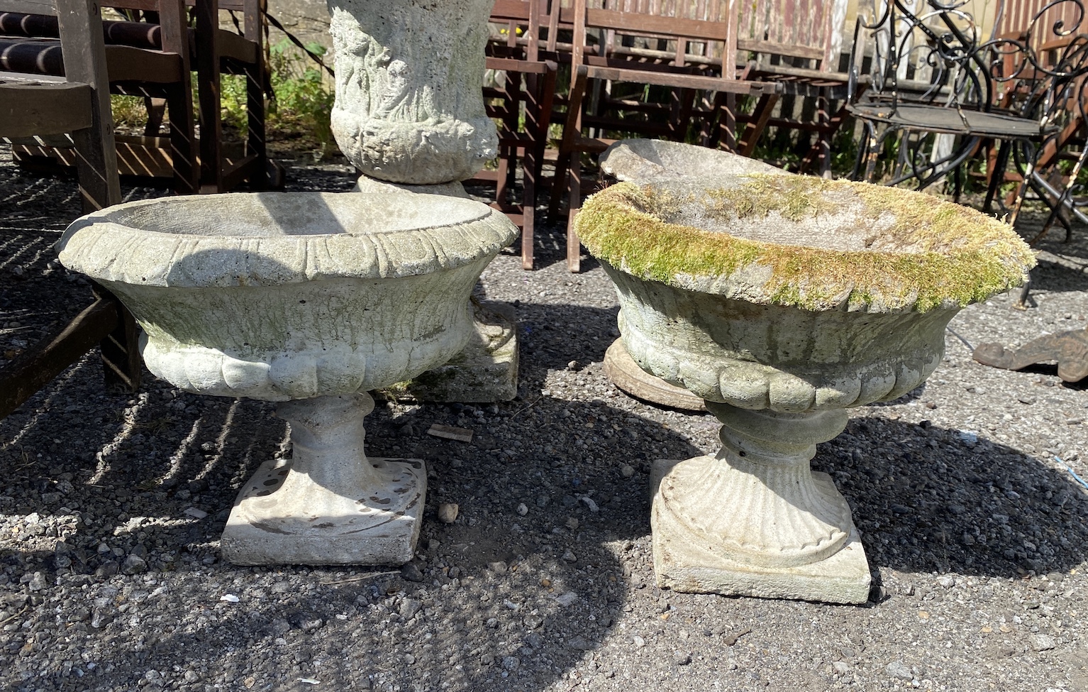 Four assorted reconstituted stone garden urns on bases, largest 61cm high